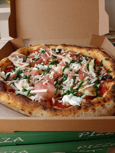 Une pizza généreusement garnie de fromage et de verdure.