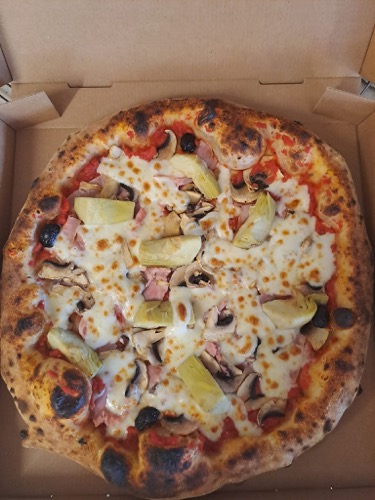 Pizza généreusement garnie avec des olives et du fromage.